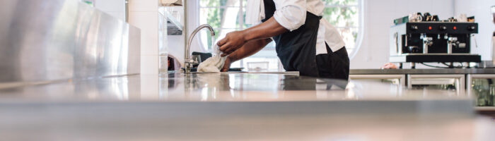 Restaurant,Employee,Soaking,A,Cloth,In,Water,For,Cleaning,Counter.