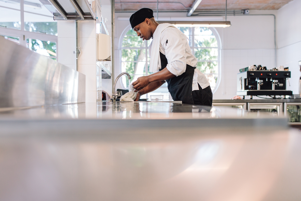 Restaurant,Employee,Soaking,A,Cloth,In,Water,For,Cleaning,Counter.